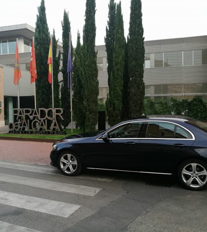 Alquiler de vehículos con conductor en Madrid - Coche negro elegante frente al Parador de Alcalá